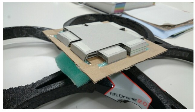 Close-up of a cardboard holder on the drone with a stack of grey marker cards.