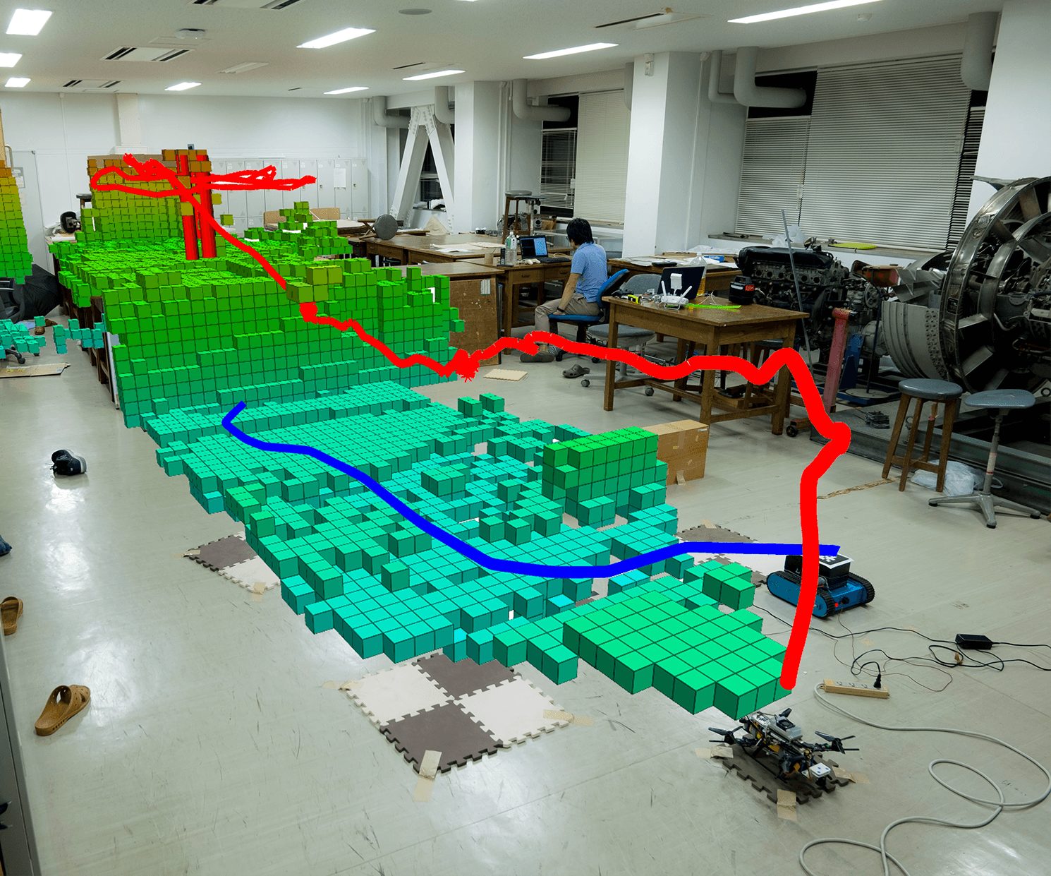 Voxel map over the field photo with the drone path in red and the ground robot path in blue